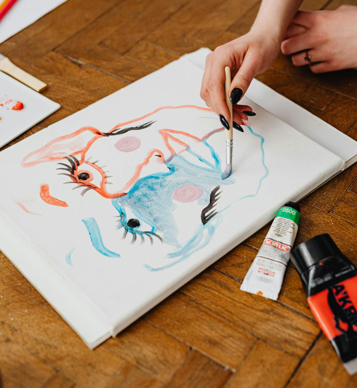 Personne peignant un visage en deux couleurs lors d’un atelier artistique